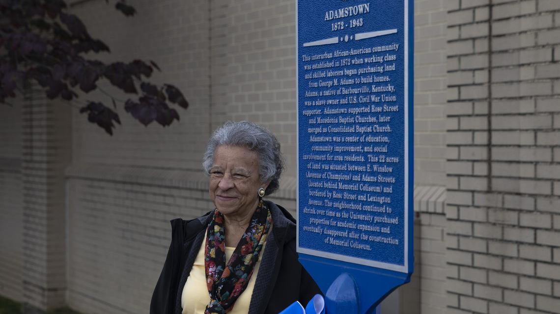 Yvonne Giles, of Lexington, poses for a photo next to a historical marker after it was unveiled Tuesday, May 14, 2019, on the University of Kentucky campus to commemorate the black neighborhood that was torn down to make way for Memorial Coliseum.