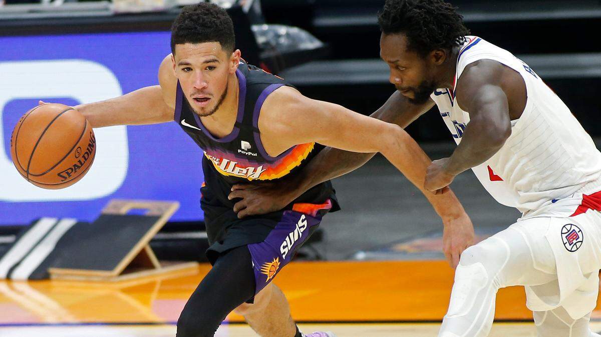 Phoenix Suns guard Devin Booker, left, drives as Los Angeles Clippers guard Patrick Beverley defends during the second half of an NBA basketball game Sunday, Jan. 3, 2021, in Phoenix. (AP Photo/Ralph Freso)