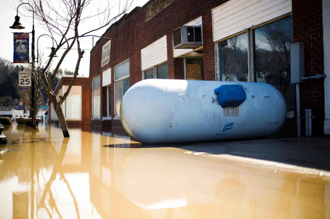 An overturned propane tank sat Tuesday along East Main Street after heavy rains caused the Kentucky River to flood most of downtown Beattyville. Local business owners have not found the owner of the tank.