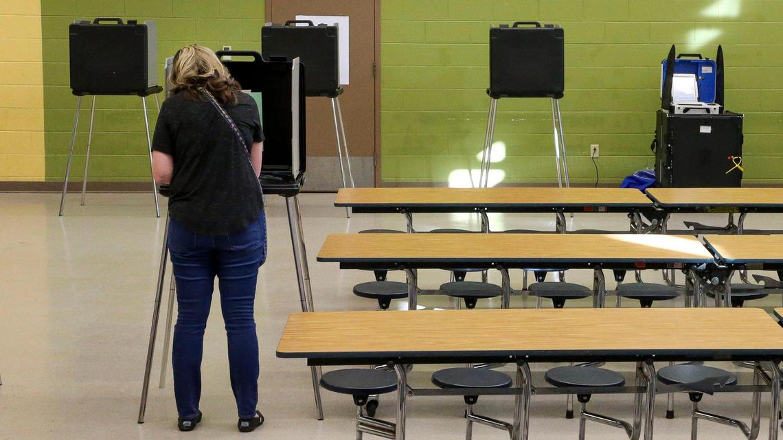 Voters cast their ballots during Kentucky’s Primary Election Day, Tuesday May 17, 2022 at the Fairway precinct in Lexington, Ky. Democrats and Republicans went to the polls to select candidates for the General Election in the fall. A new type of voting machine, first used in Kentucky’s 2022 Primary Election, is seen in the background at right. The machines, called the InterCivic are made by the Hart company. It uses a paper ballot, first filled out by the voter, and then scanned into the machine.