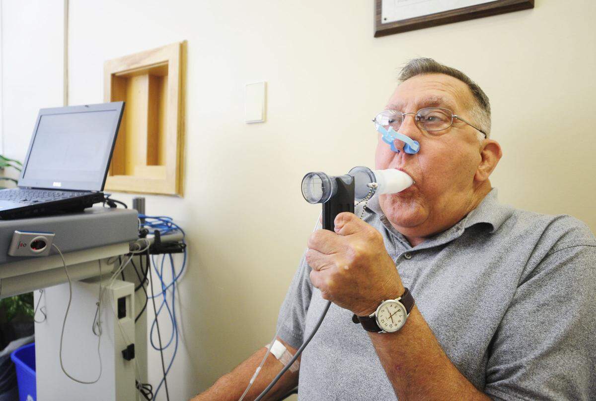 Ernie Gillispie was diagnosed with black lung after 37 years working in Kentucky coal mines. He blew into a machine to test his oxygen output during a checkup after a double-lung transplant.