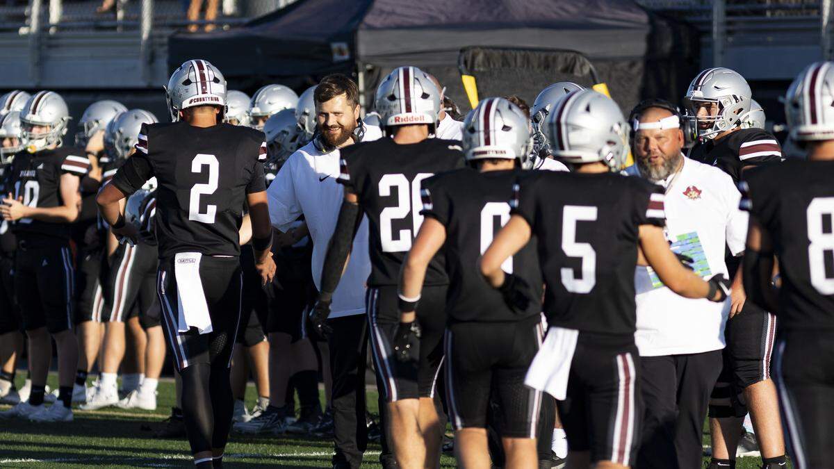 Pulaski County head coach Travis Burns, at left, congratulates Maroons quarterback Zak Anderson (2) and other offensive players after a successful touchdown drive late in a 49-27 win against Bryan Station in the Rebel Bowl at Boyle County High School in Danville on Saturday.