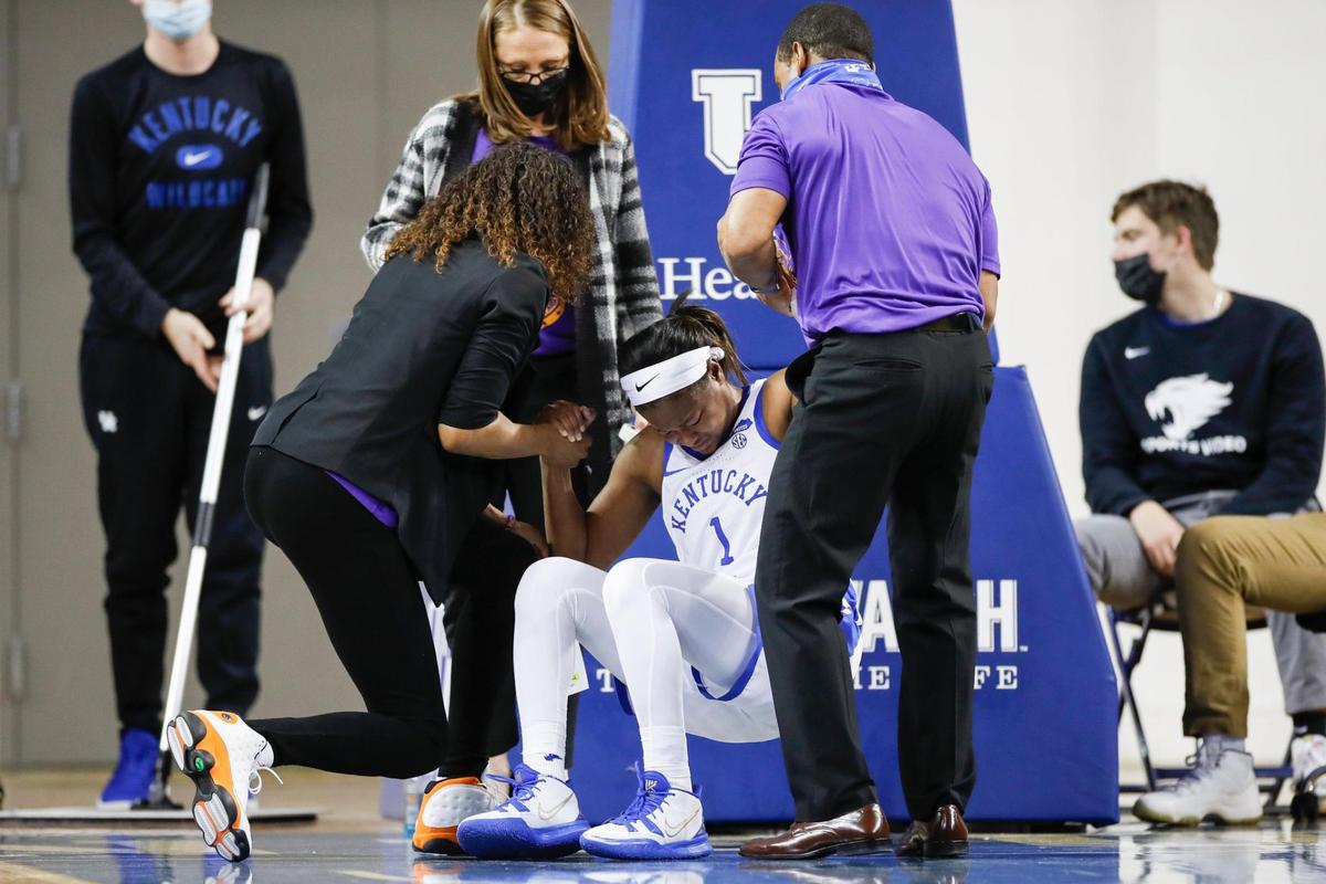 Kentucky Wildcats guard Robyn Benton (1) is helped off the court after being inured during the game against the Florida Gators at Memorial Coliseum in Lexington, Ky., Thursday, January 20, 2022. Benton will not play Sunday at home against Ole Miss due to an ankle injury.