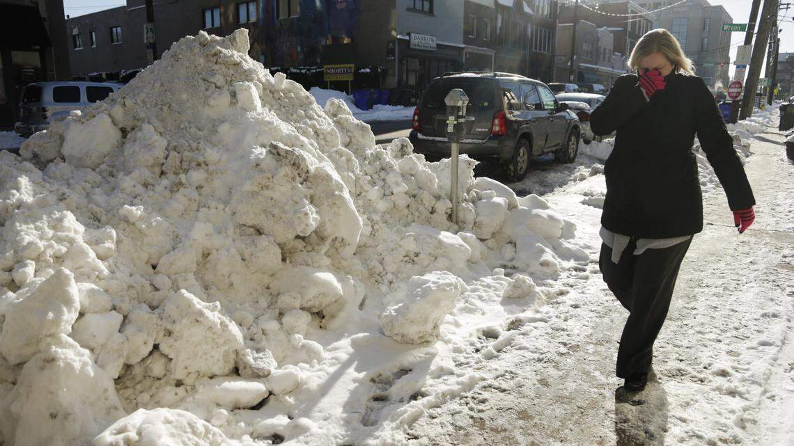 Robin Anderson of the Fayette County commonwealth's attorney's office walked past a snow bank bigger than many SUVs Friday morning in downtown Lexington.    