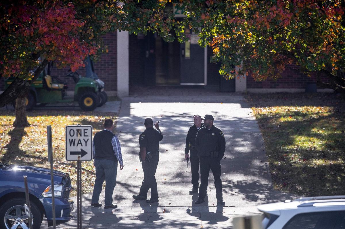 Members of law enforcement and school officials stand outside Henry Clay High School in Lexington, Ky., on Thursday, Oct. 27, 2022.