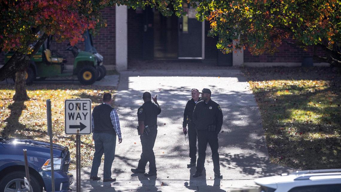 Members of law enforcement and school officials stand outside Henry Clay High School in Lexington, Ky., on Thursday, Oct. 27, 2022.