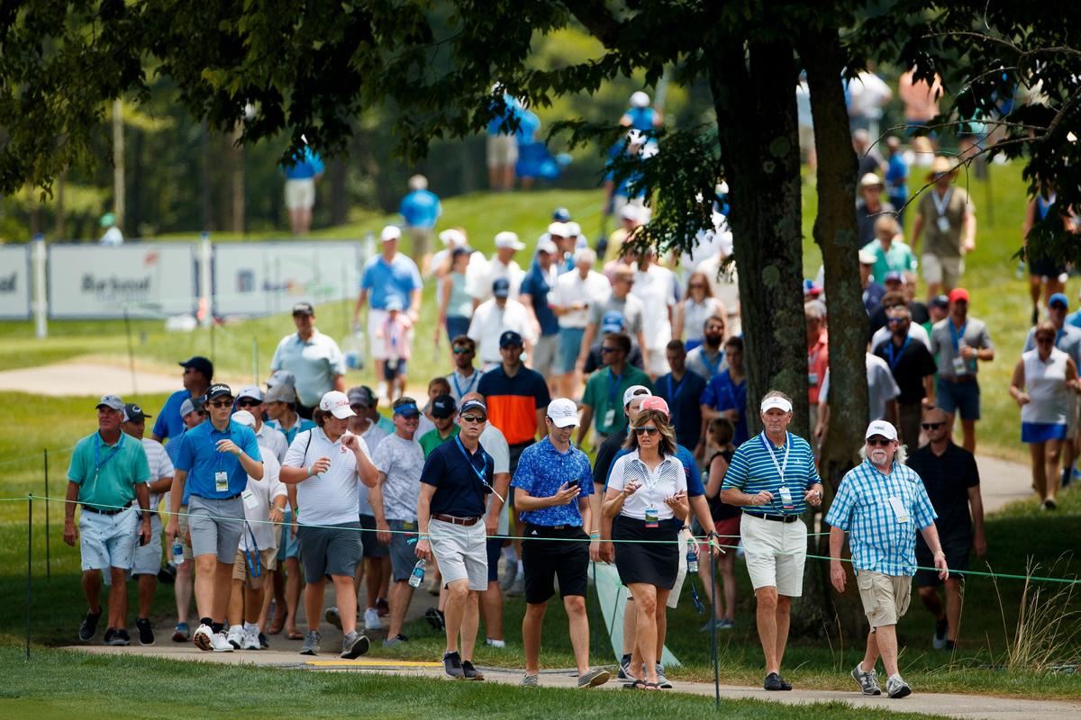 Fans follow John Daly as he makes his way up the 18th fairway during the first round of the PGA Barbasol Championship.