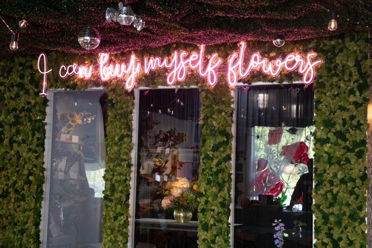 Lyrics from Miley Cyrus hit single "Flowers" glow bright in neon pink at Poppy’s Flower Bar, located at 210 Old Mt Tabor Rd on Oct. 4, 2025, in Lexington, Ky.
