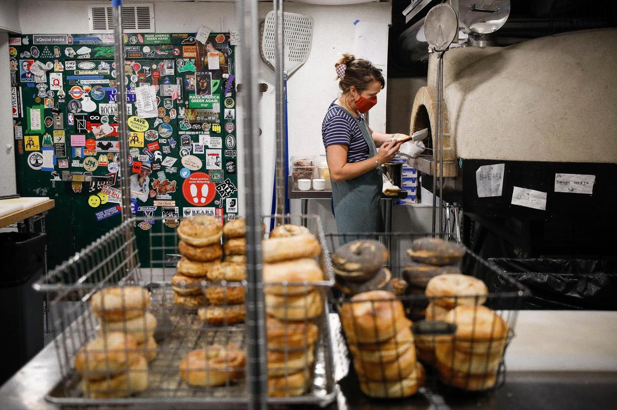 Pearl’s owner and general manager Colleen Mahan makes a bacon egg and cheese bagel sandwich Aug. 19 at the wood-fired oven at Pearl’s.