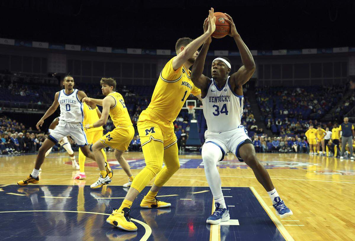 Kentucky’s Oscar Tshiebwe (34) drives against 7-foot-1 Michigan center Hunter Dickinson (1) during their game last December in London.