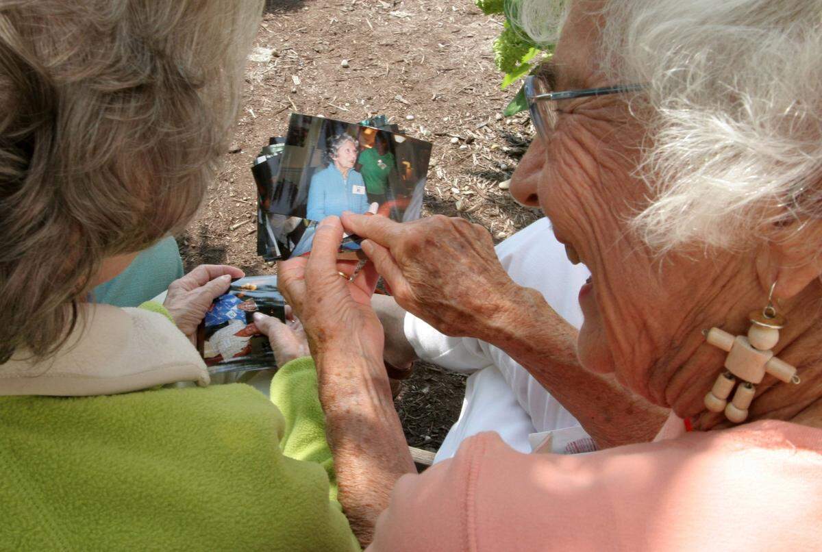 Virginia Bell, right, shares some photographs with a participant at Best Friends Day Center in Lexington on September 16, 2005.