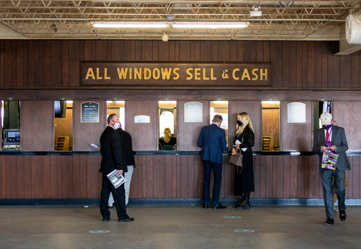 Patrons place bets at windows during the Breeder’s Cup World Championships at Keeneland in Lexington, Ky., Friday, November 6, 2020.
