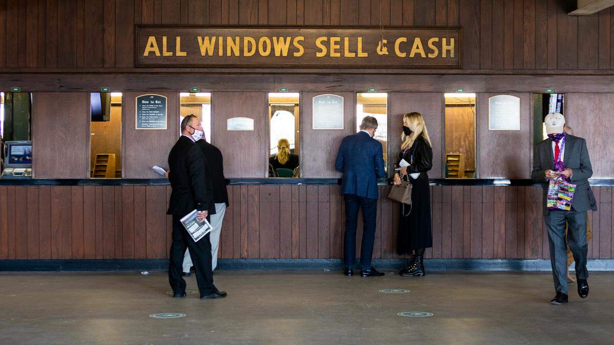 Patrons place bets at windows during the Breeder’s Cup World Championships at Keeneland on Nov. 6, 2020. When sports gambling is allowed in Kentucky, in-person retail bets must be placed at any of the nine horse racing tracks and their casino-style venues.