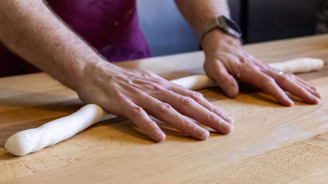 On day two of making authentic German-style pretzels at The Wandering Bock Pretzel Pub & Brat Haus, co-owner Jeremy Markle mixes the dough in an industrial mixer and then rolls and shapes the sourdough. Markle then twists the dough into his signature braided circular shape. The three hour process on day two will yield about 40 of the 7-ounce Papa Pretzels. 