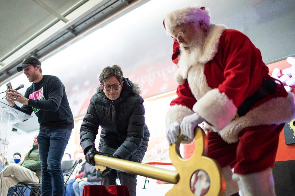 Lexington Mayor Linda Gorton and Santa lifted a key to light the Christmas tree at Triangle Park.