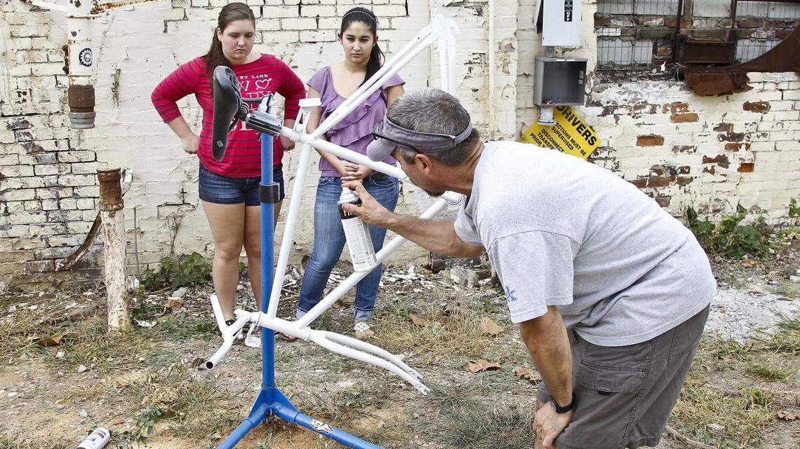 Allen Kirkwood came to the Broke Spoke Community  Bike Shop on Saturday morning to help build the "ghost bike" in memory of his friend.  
Tiffany, left, and Jennifer (daughters of Kerr) watched Kirkwood spray on a coat of white paint on the bike.