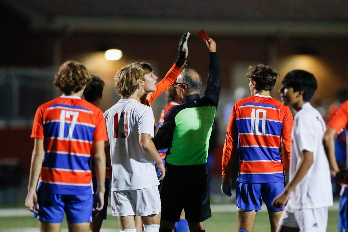 A referee holds up a red card while Frankfort players and Paul Laurence Dunbar players get into an argument during the boys’ 11th Region semifinals at Madison Central High School on Thursday night.