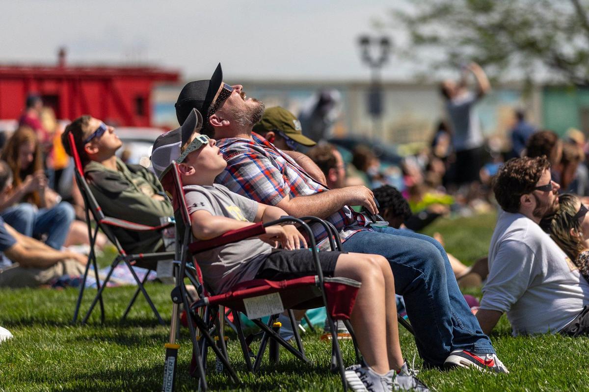 Lorne and Samuel James, 12, of Hendersonville, Tenn., watch a solar eclipse on the riverfront in Paducah, Ky., on Monday, April 8, 2024.