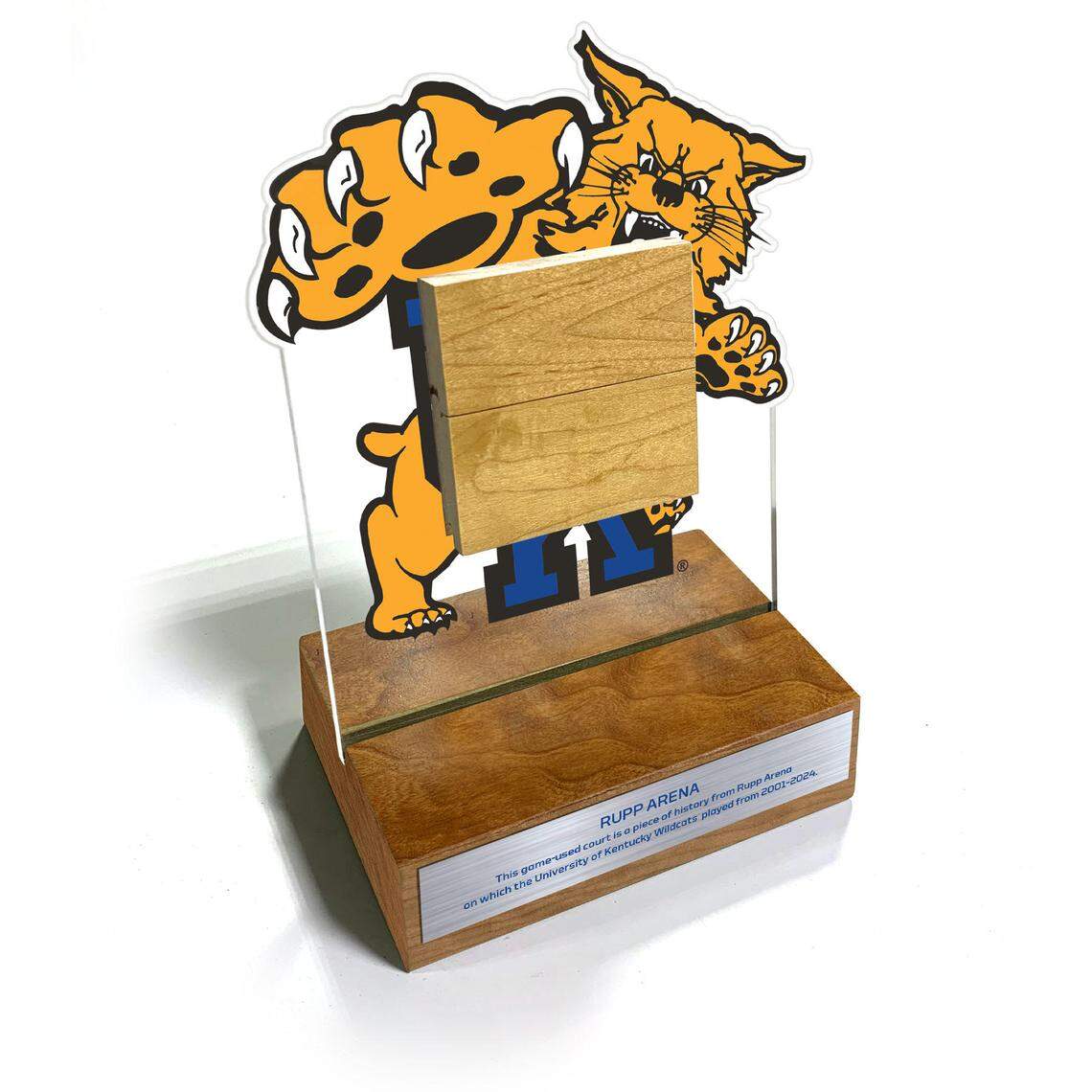 The Rupp Arena desk frame features a 3-by-3 inch block of game-used court from Rupp Arena. The block of court wood is locked into an acrylic frame, appearing to float above the cherry base.