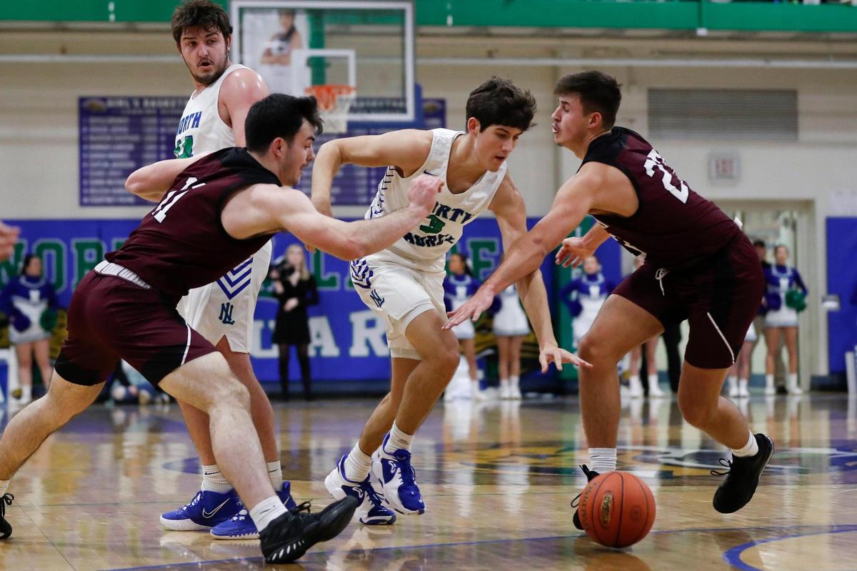 North Laurel’s Reed Sheppard (3) dribbles through Pulaski County’s Zach Travis (11) and Caleb Sloan (23) at North Laurel High School in London on Tuesday night. Sheppard, who has committed to the University of Kentucky, led the Jaguars to the win with 29 points, 16 of them coming from the free throw line.