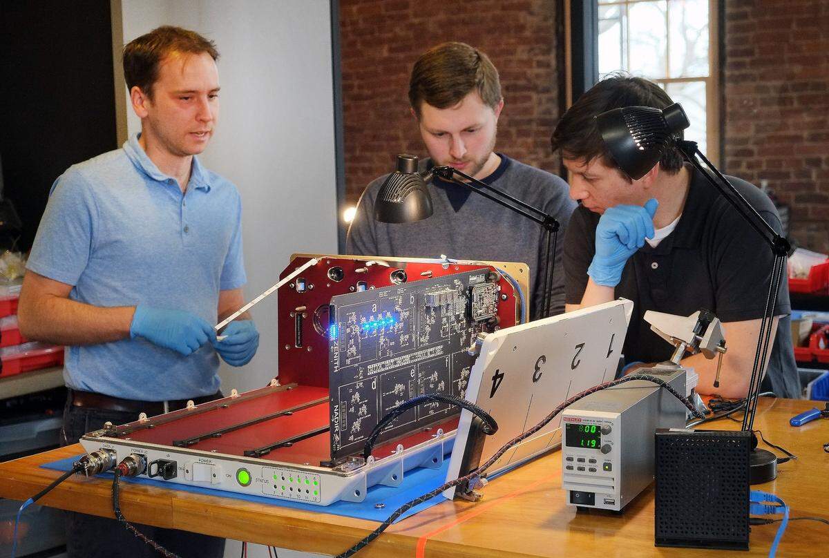 Space Tango CEO Twyman Clements, left, worked in February 2016 with Jason Rexroat, center, and Zach Jacobs on the cabinet that will hold experiments for the Lexington company's clients aboard the International Space Station. The first set of experiments is scheduled to be taken to the space station July 16.