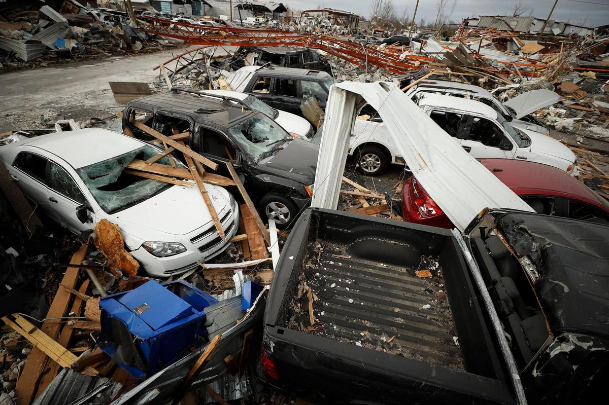 Cars sit destroyed in a lot near Chili Motors on West Broadway in Mayfield, Ky., Wednesday, Dec. 15, 2021.