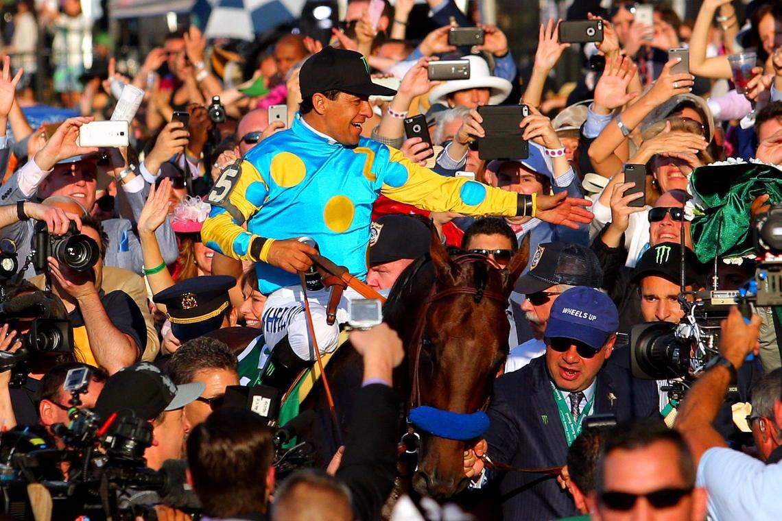 American Pharoah, with jockey Victor Espinoza, is led to the winner’s circle by owner Ahmed Zayat after winning the 2015 Belmont Stakes in New York to become horse racing’s first Triple Crown winner since 1978.