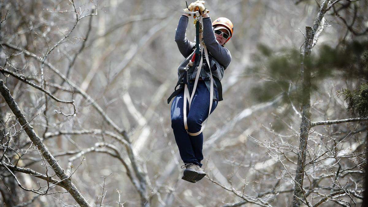 Mackenzie Leachman held on to the zip line at Boone Creek Outdoors last year, before the Fayette County business was ordered to halt the canopy tours because of zoning issues.