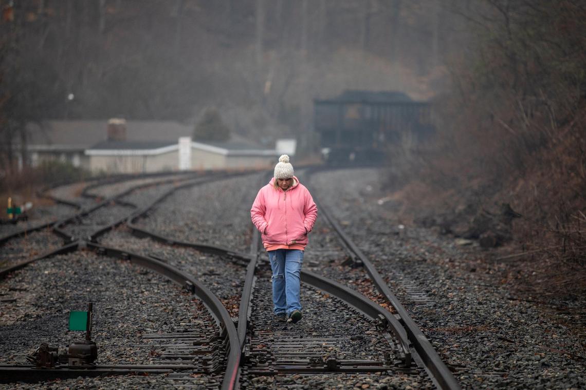 Jennifer Blackburn, whose husband works for Quest Energy, walks on railroad tracks where miners, who say they haven’t been paid in three weeks, block a coal train in Pike County, Ky., Tuesday, Jan. 14, 2020.