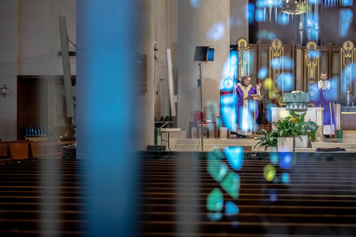 Bishop John Stowe, left, celebrates Mass at Cathedral of Christ the King in Lexington, Ky., Sunday, March 29, 2020. The church is webcasting its services — which are temporarily closed to parishioners — in response to the coronavirus pandemic.