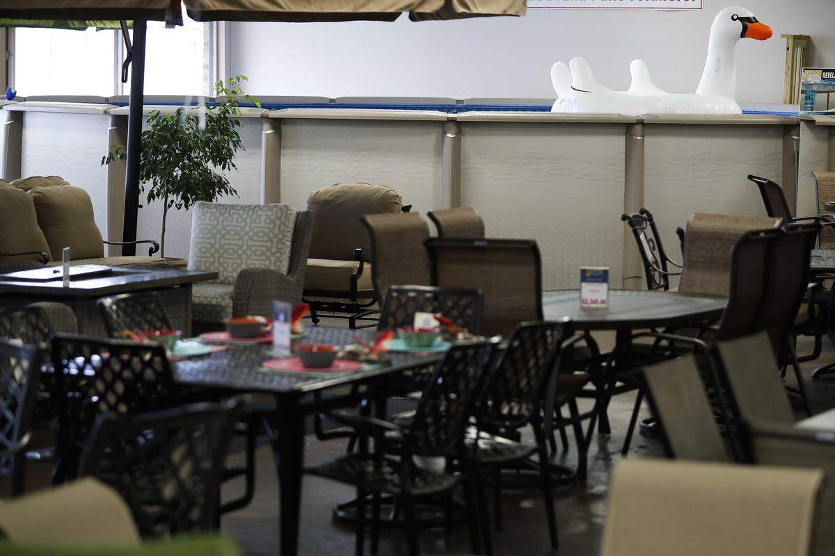 An inflatable swan-shaped pool raft floats in a display pool Wednesday at Aurora Pools & Spas in Lexington.