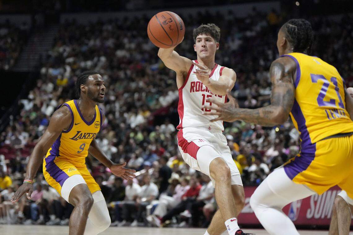 Houston Rockets guard Reed Sheppard passes the ball between the Lakers’ Bronny James, left, and Maxwell Lewis.