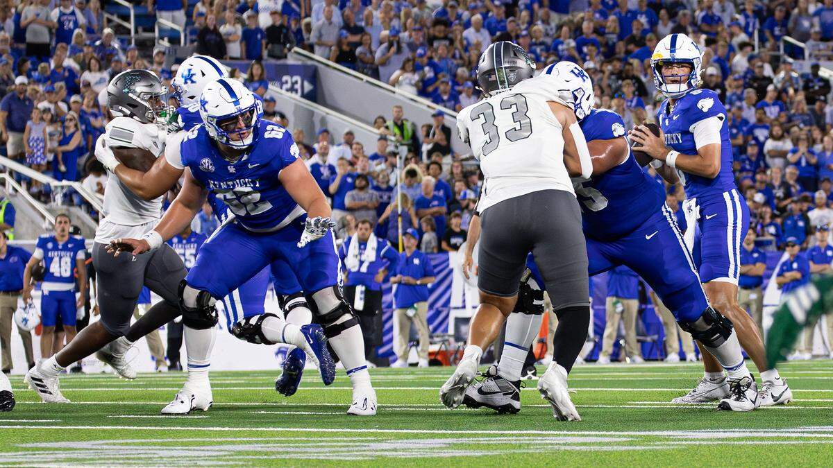 Kentucky center Jager Burton (62) helps the rest of the offensive line buy quarterback Cutter Boley (8) time as he looks for an open receiver against Eastern Michigan at Kroger Field on Saturday.