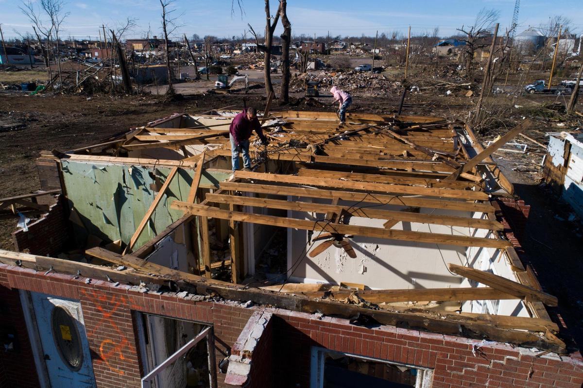 Robert Davis, left, and Amber Amaro, both of Murray, Ky., work to salvage materials from a friend’s home on North 6th Street in Mayfield, Ky., Wednesday, Jan. 5, 2022.