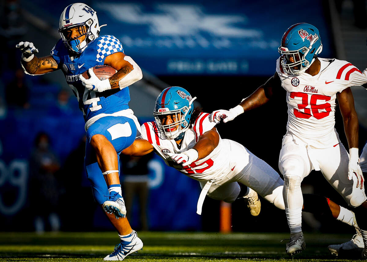 Kentucky Wildcats running back Christopher Rodriguez Jr. runs the ball past Mississippi Rebels linebacker Tavius Robinson, center, and Mississippi Rebels linebacker Ashanti Cistrunk during their game at Kroger Field in Lexington, Ky., Saturday, Oct. 3, 2020. Mississippi beat Kentucky 42-41.