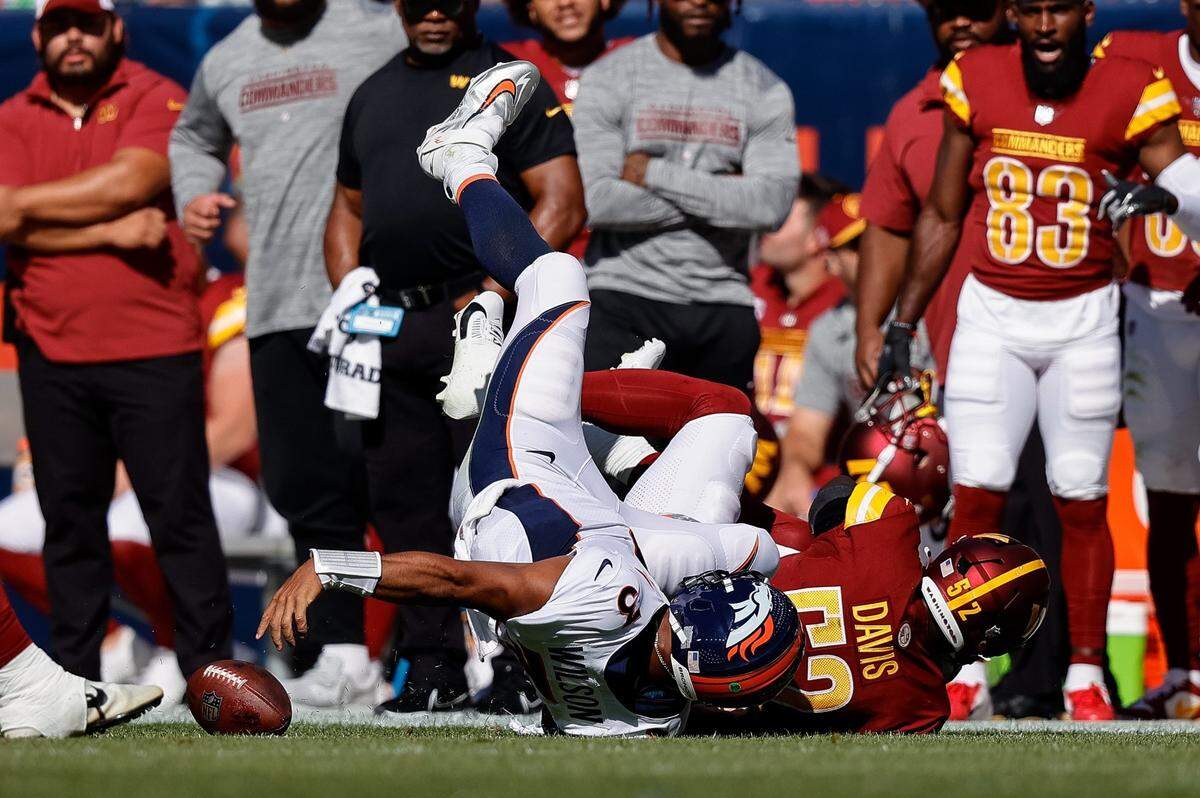 Broncos quarterback Russell Wilson (3) fumbles the ball as he is tackled by Commanders linebacker Jamin Davis (52) in the second quarter on Sunday in Denver.