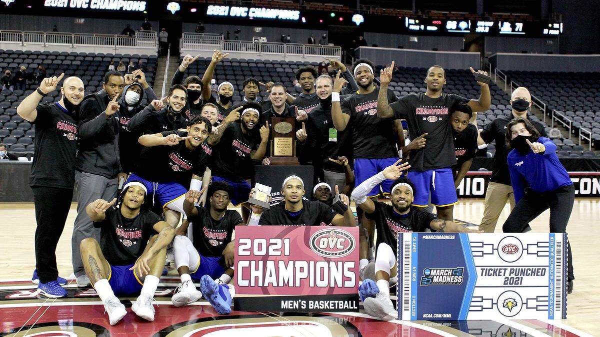 Morehead State players gathered around head coach Preston Spradlin with the championship trophy after winning the Ohio Valley Conference Tournament and an automatic bid to the NCAA Tournament on Saturday night in Evansville, Ind.