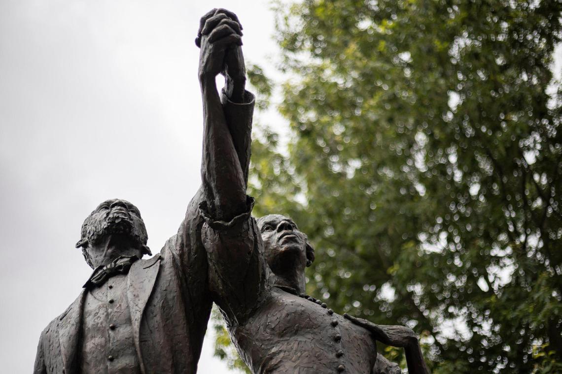 The faces of Lewis and Harriet Hayden are revealed during the ‘Towards Freedom’ monument unveiling on Thursday, June 19, 2025, at the corner of North Limestone and Fourth Street in Lexington, Ky.