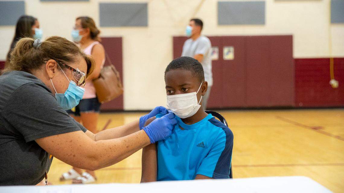 Sherry Cox, a Lexington-Fayette County Health Department registered nurse, gives a COVID-19 vaccine to Amari Thompson, 12, at a vaccination clinic hosted by the Lexington-Fayette County Health Department and Fayette County Public Schools at Leestown Middle School in Lexington, Ky., on Friday, Aug. 20, 2021.