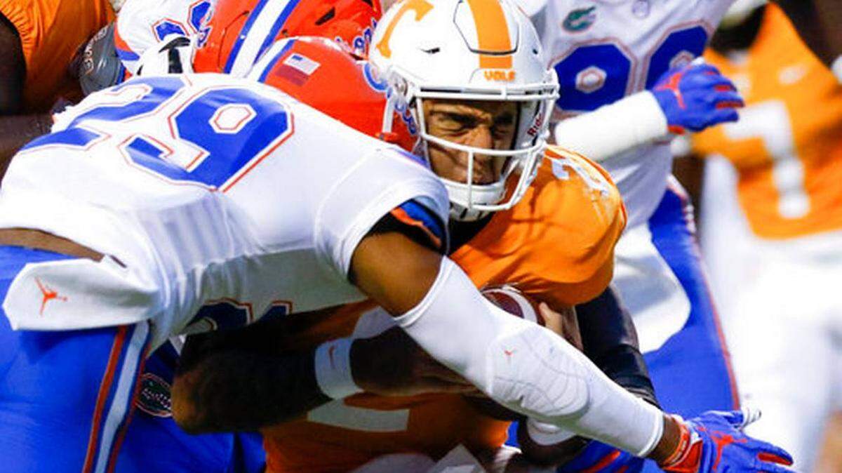 Tennessee quarterback Jarrett Guarantano (2) reacts as he is hit by Florida defensive lineman Tedarrell Slaton (56) and defensive back Jeawon Taylor (29), Saturday, Sept. 22, 2018, in Knoxville, Tenn. Chattanooga Times Free Press via AP C.B. Schmelter