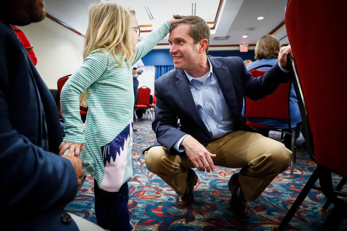 Kayleigh Stephens, 4, of Georgetown, Ky., greets Kentucky Attorney General and democratic candidate for Governor Andy Beshear during the Scott County candidate reception at the Hilton Garden Inn in Georgetown, Thursday, Oct. 24, 2019.