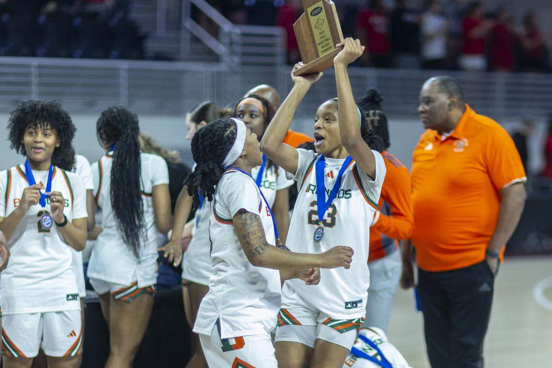 Frederick Douglass' Jaelee Knowles (23) hoists a trophy following a victory against Paul Laurence Dunbar during the Girls 11th Region Tournament championship game at Eastern Kentucky University's Baptist Health Arena in Richmond, Ky., on Sunday, March 8, 2026.
