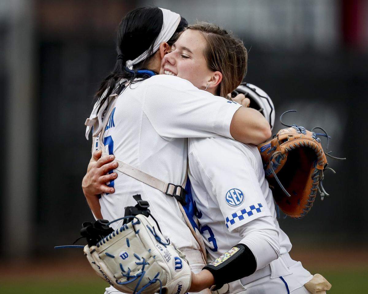 Kentucky softball sophomore pitcher Stephanie Schoonover, right, and senior catcher Kayla Kowalik hug after Schoonover threw a no-hitter in five innings in UK’s 9-0 win over Louisville on April 12.