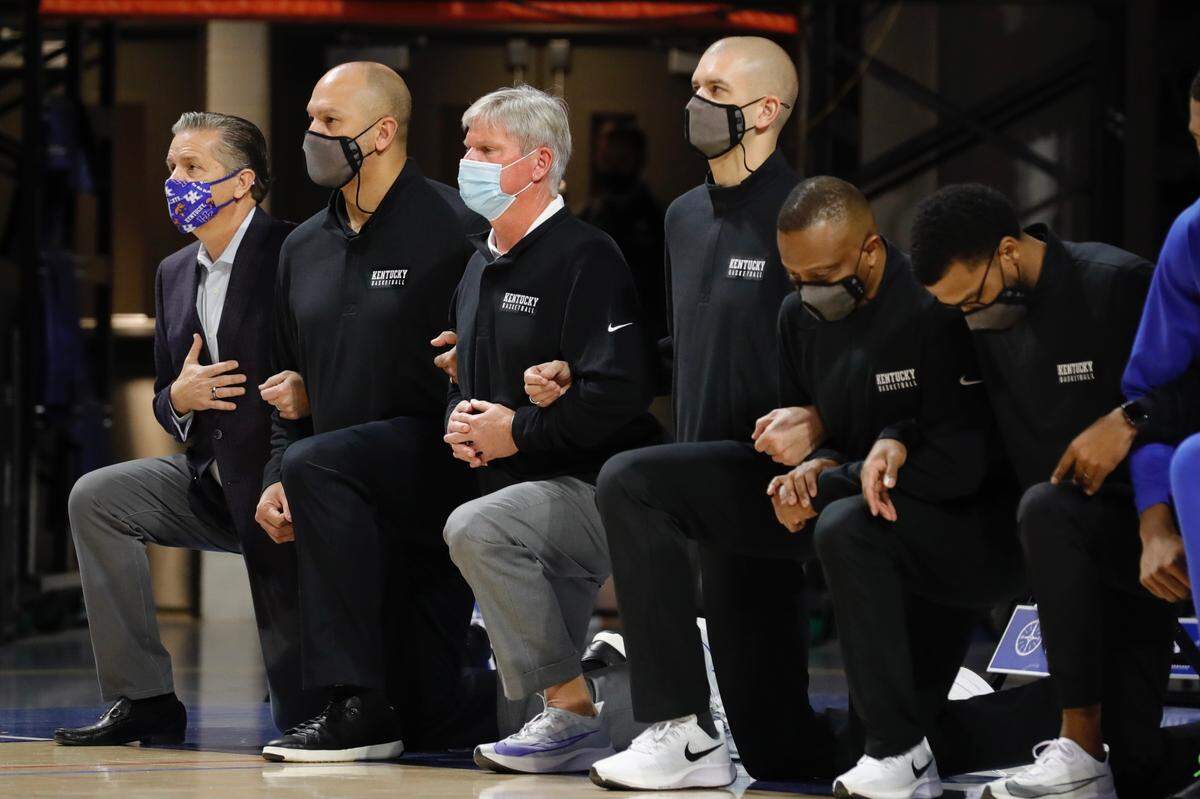 John Calipari, left, and the Kentucky coaching staff joined the players in kneeling during the national anthem before Kentucky’s game against Florida.