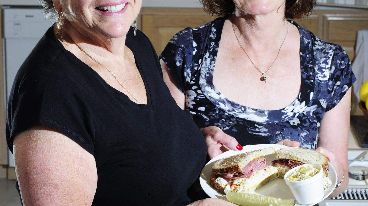 Ruth Poley, left, and Pat Shraberg, who helped found TAI on Rye deli at Temple Adath Israel, showed off one of its signature sandwiches: the edible complex.