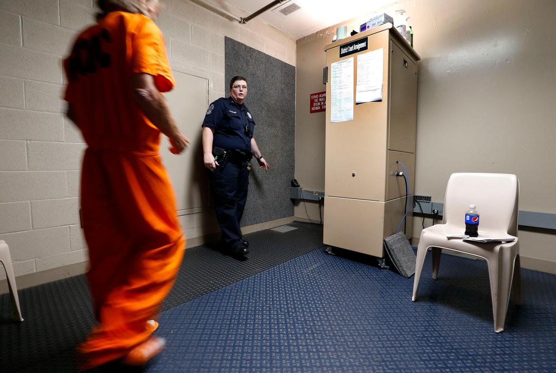 Cpl. Sam Collier led an inmate to the camera and monitor for a district court video arraignment Friday afternoon in the Fayette County Detention Center 600 Old Frankfort Pike. The inmates entered a small room where they stood against a carpeted wall and communicated with the judge via video connection.