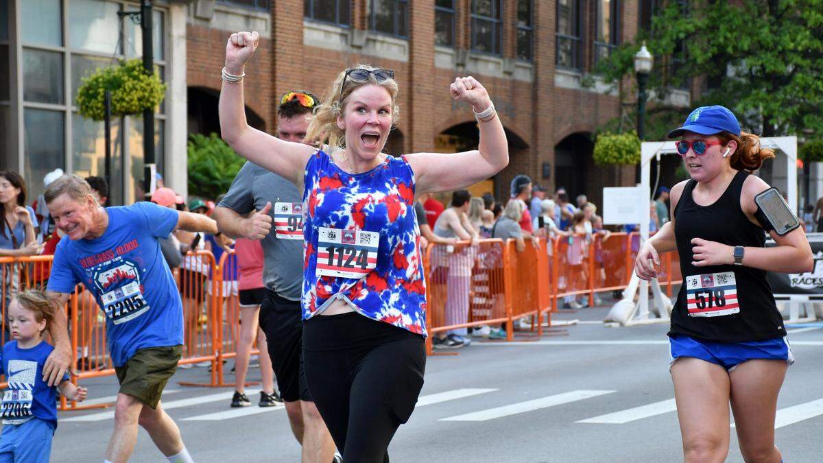 Kelsey Jones, center, celebrates crossing the finish line in the Bluegrass 10,000.
