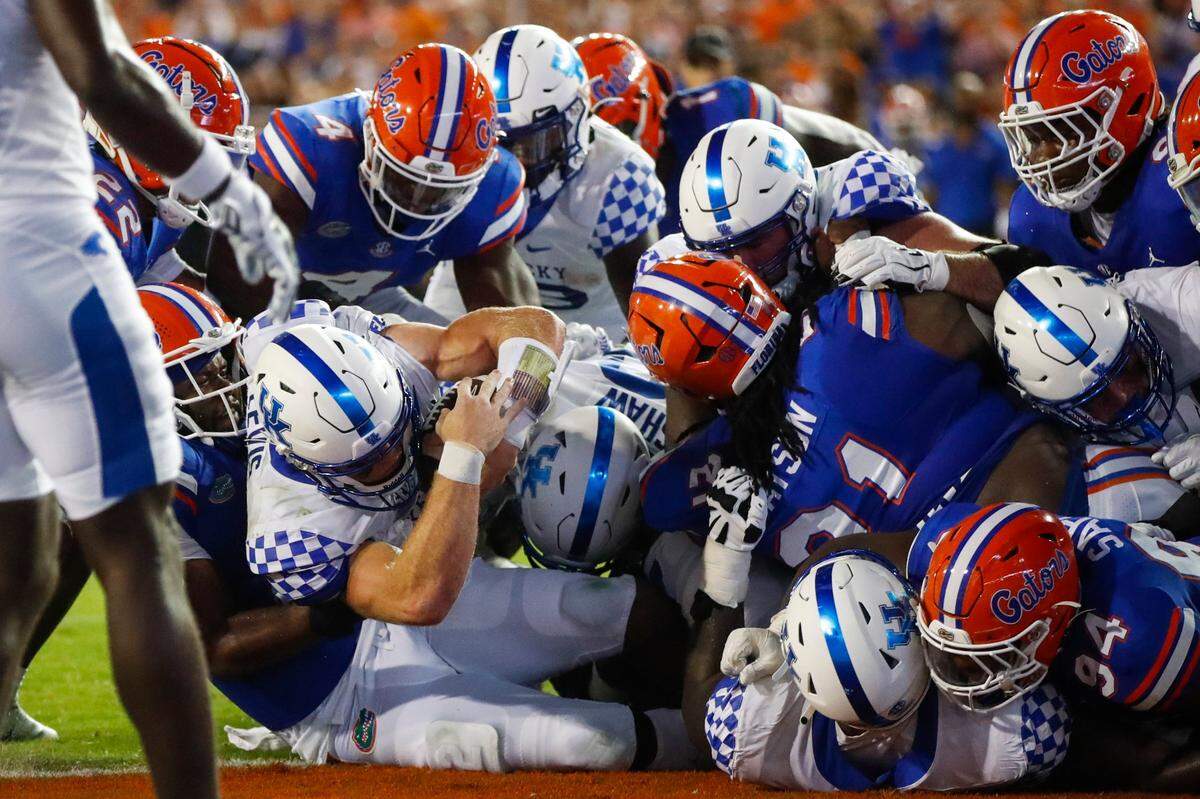 Kentucky quarterback Will Levis, bottom left, is pushed into the end zone to score a touchdown against Florida during Saturday’s game at Ben Hill Griffin Stadium in Gainesville, Fla.