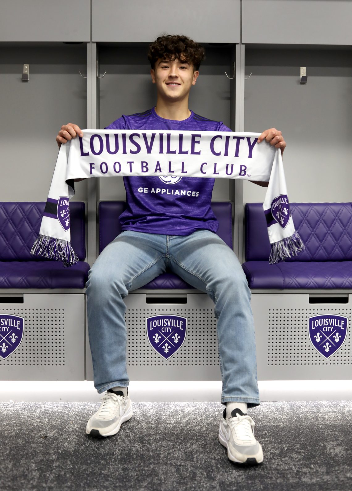 Owen Damm poses with a Louisville City FC scarf after signing a professional contract with the club. As part of Damm’s contract, he will also receive an academic scholarship to pursue an undergraduate degree at Bellevue University.