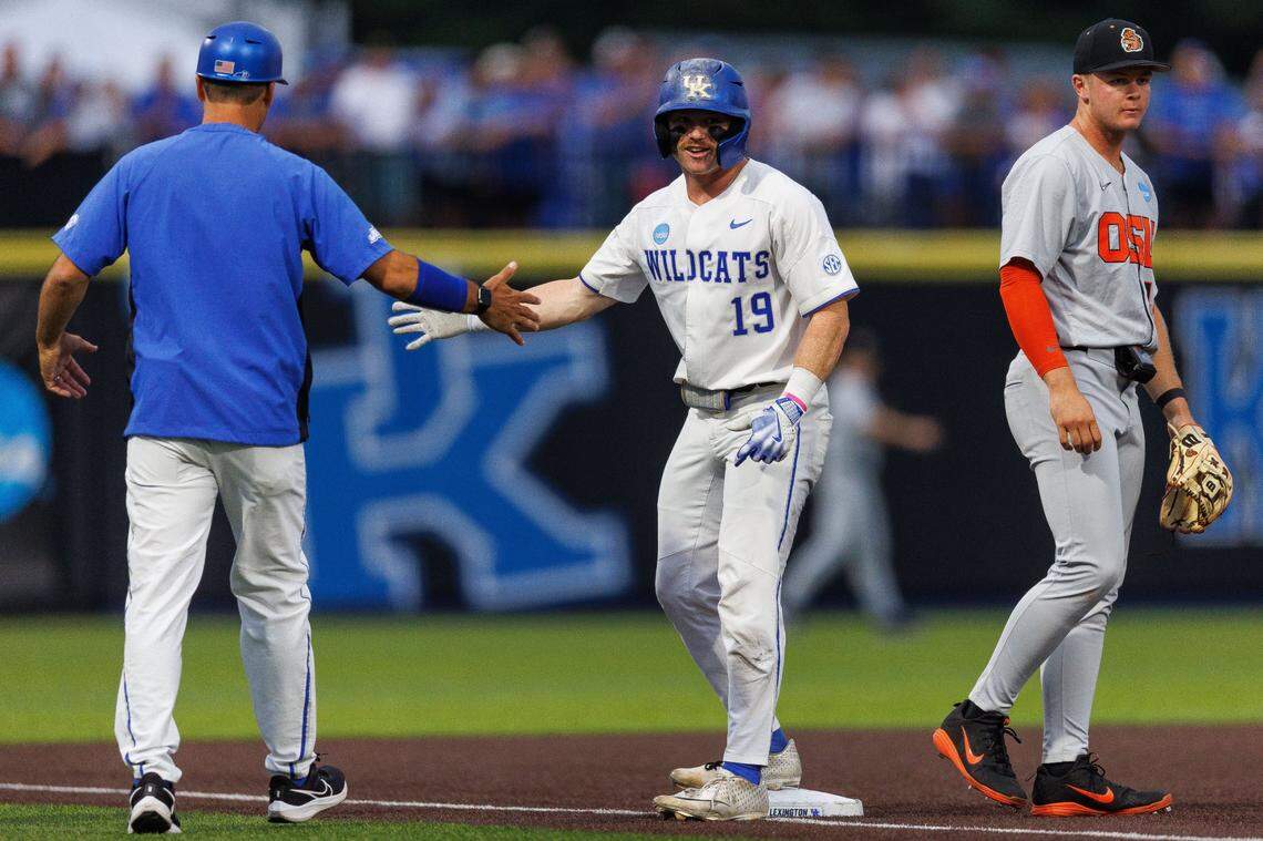 Kentucky outfielder Nolan McCarthy (19) fives head coach Nick Mingione after stealing third base during the seventh inning against Oregon State at Kentucky Proud Park. UK won 10-0.